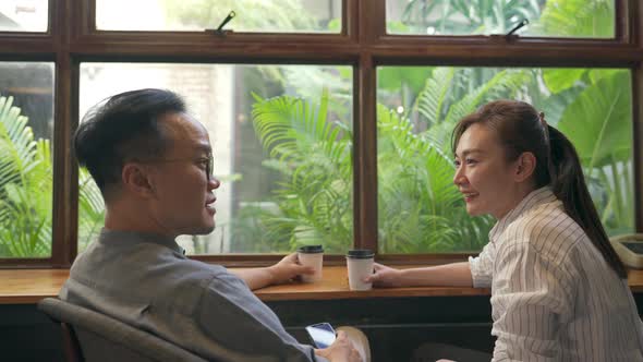 4K Asian man and woman meeting and talking together at coffee shop alt