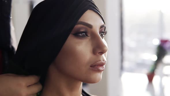 Beautiful Girl with Traditional Arabic Black Hijab Covering Her Head By Unrecognizable Woman Behind alt