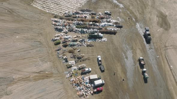 Aerial View of Trucks Delivering Loads of Solid Waster Into Industrial Landfill alt