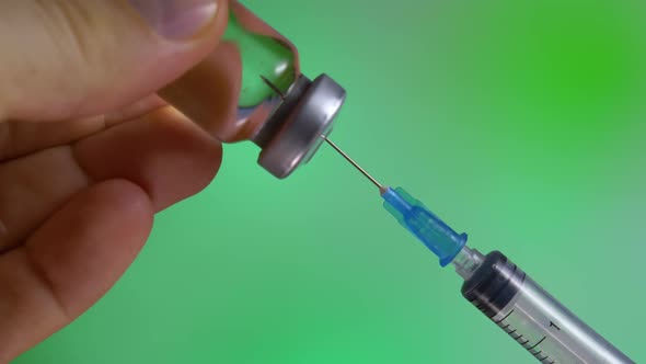 Flu Vaccine Into Syringe on Green Background