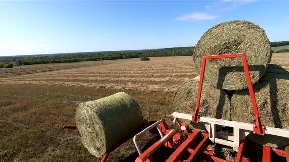 Tractor Collects the Haystacks Into the Cart. Collection of Hay for the Winter, Hay Supply. Modern