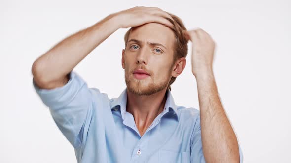 Good Looking Caucasian Bearded Male with Light Brown Hair and Blue Eyes Adjusts His Shirt Collar on alt