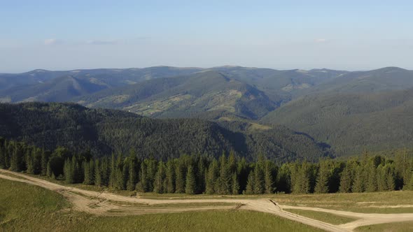 Aerial View of Mountain Peaks Covered with Dense Pine Forest alt