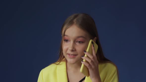 A Teenage Girl in Smart Clothes is Chatting on the Phone with Her Girlfriend alt