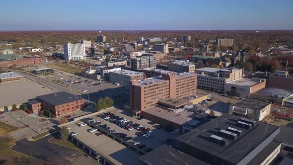 Wide aerial of trafficked streets in Muskegon, MI, backward motion alt