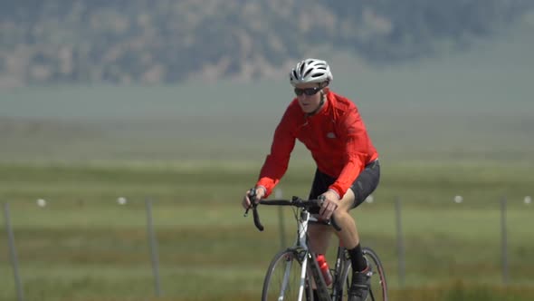 A man road biking on a scenic road. alt