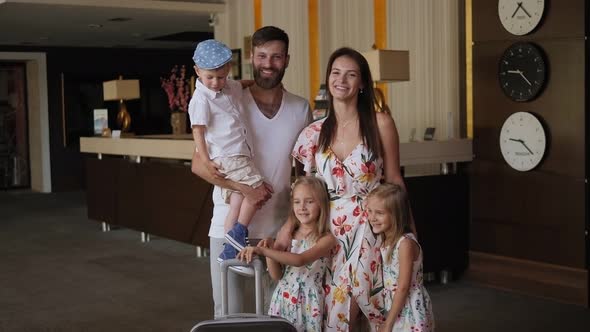 Portrait of a Family in the Hotel Lobby with a Suitcase. Slow Motion. alt