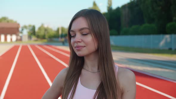 Beautiful Blonde Woman Athlete at the Stadium Breathing and Preparing to Start the Race alt