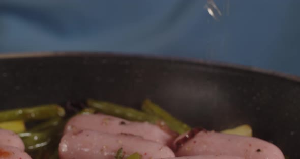 Add Lemon Juice To Asparagus With Onions And Sausages. Hot Dish alt