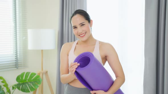Portrait of Asian woman stand with confidence after exercise in house. alt