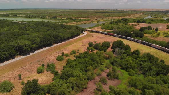 Aerial Of Countryside With A Cargo Train And Lakes