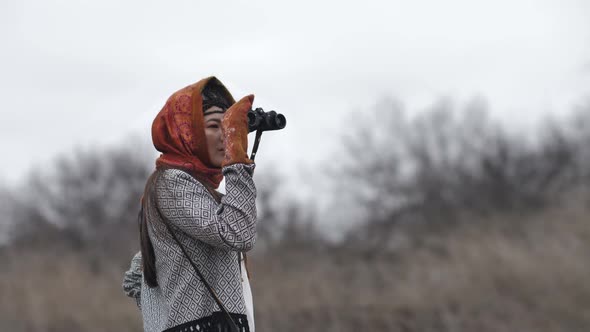 portrait of asian young woman looking through binoculars. Slow motion alt