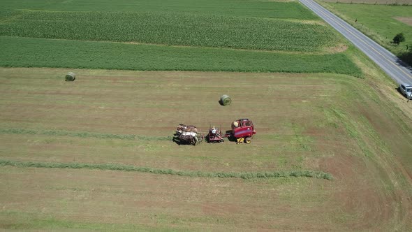 Aerial View of an Amish Farmer Harvesting His Crop with 4 Horses and Modern Equipment alt