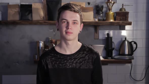 Portrait of caucasian barista smiling and standing inside bar or coffee house.