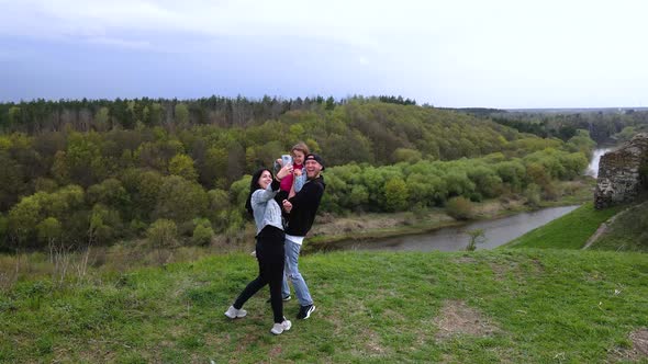 Happy family taking selfie by smartphone on the coast Sluch river hills