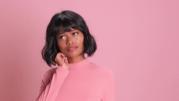 Adorable Ethnic Young Woman Bites Lips Grins Happily Has Thoughtful Dreamy Face alt