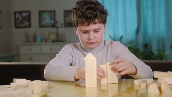 child is playing. The boy builds from wooden blocks. Creative thinking