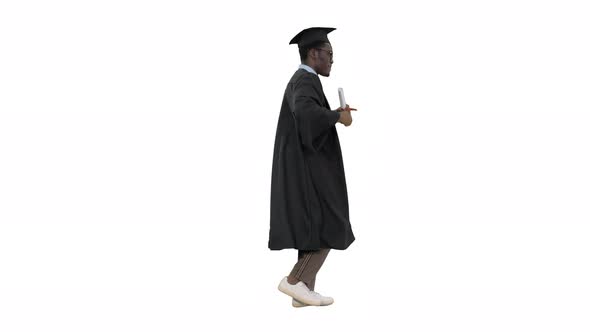 Excited African American Male Student in Graduation Robe Dancing with His Diploma While Walking on alt