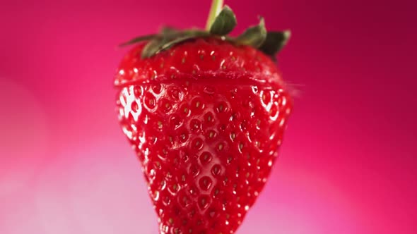 Strawberry Slice Falling and Splashing on Pink Background alt