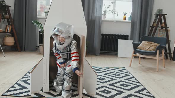 Cute Girl in Spacesuit Exiting Rocket Ship and Waving alt
