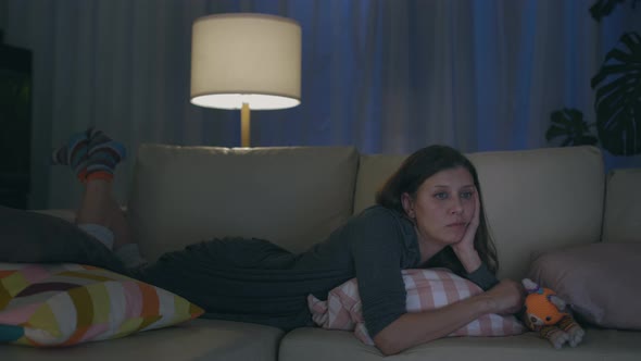 Adult Beautiful Lonely Woman Evening Home Sitting On Sofa And Watching TV alt