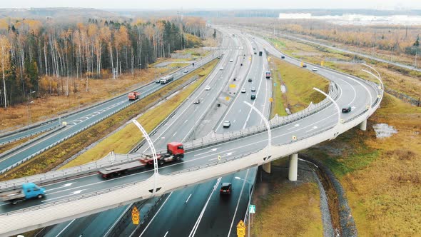 Cars Drive Fast on Wide Highway and Overpass Road in Autumn alt