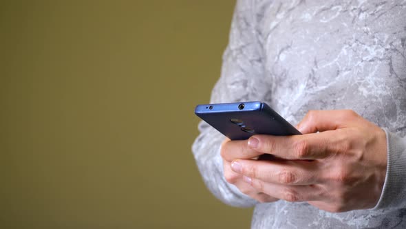 Man Texting and Browsing Internet in His Smartphone