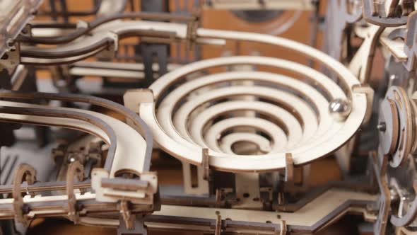 Close Up Detail Of A Marble Run Toy Machine With Wooden Gears Moved With Hand Crank. zoom-out alt