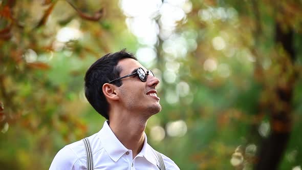Young guy in sunglasses in autumn park