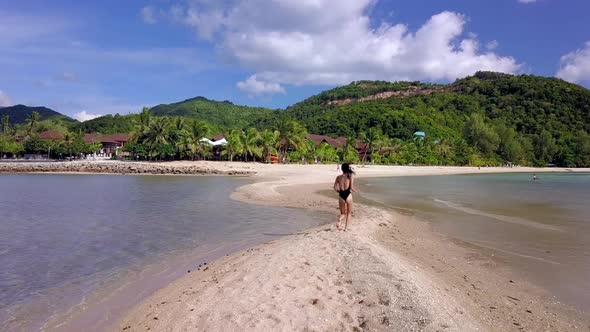 Pretty Woman in Black Swimsuit Running Alone on a SandbarThailand