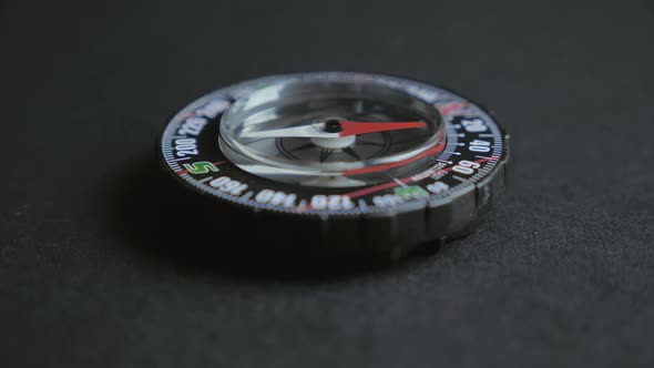 Extreme Close Up of a Transparent Modern Compas on Black Background. Concept of Travel, Adventure alt