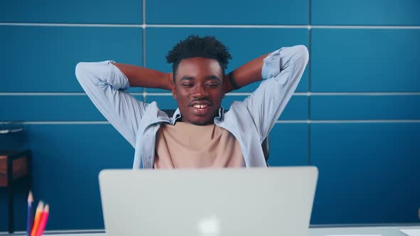 Successful African American Man Put Hands Behind Head Feels Satisfied in Office alt