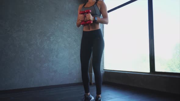 A Sports Woman Doing Sit-ups and Jumping, She Is Holding Dumbbells alt