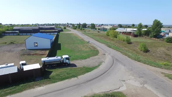Aerial View of Tank Trucks Delivering Beer and Riding Out of Manufacture Yard on Rural Road in