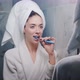 Young Beautiful Woman in the Bathroom Brushing Her Teeth in Front of the Mirror - VideoHive Item for Sale