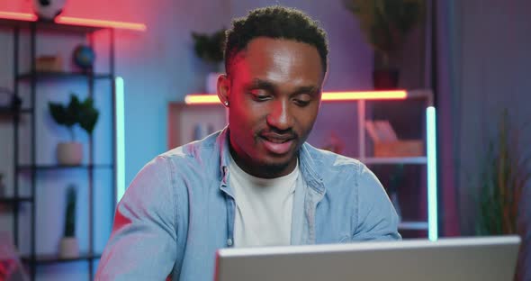 Black-Skinned Guy Sitting in front of Computer and Reading News from friends alt