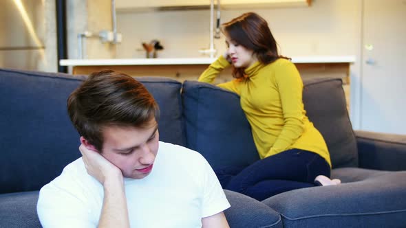 Woman ignoring man while argument in living room alt