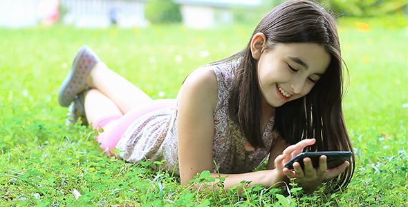 Girl Playing Outdoor with Her Smart Phone alt