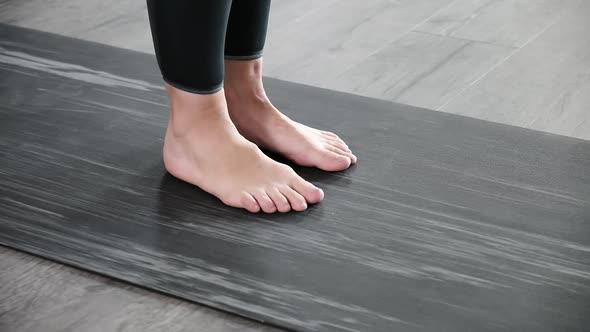 Closeup on Legs of Barefoot Woman on Mat Warming Up Preparing for Exercises alt