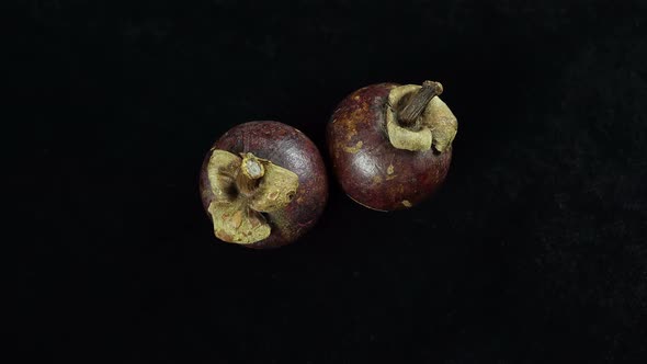Rotating Tropical Fruit Mangosteen On A Black Background.