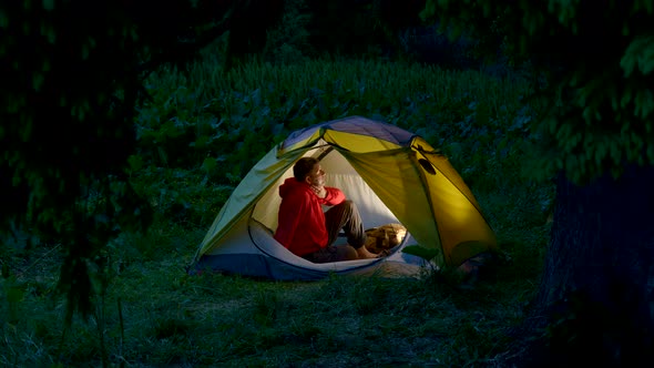 A Man in a Tent in the Night Forest alt