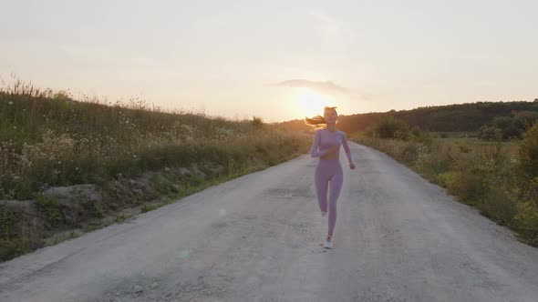 Concetrated Young Lady Runs on the Road in Tracksuit alt
