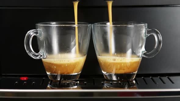 Coffee From the Coffee Machine Is Poured Into Glass Cups alt