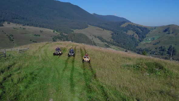 Tourists on Sport Quad Bikes on Beautiful Mountains Background alt