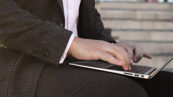 Businessman Is Working in Park Outdoors Typing on Laptop, Closeup Hands View.