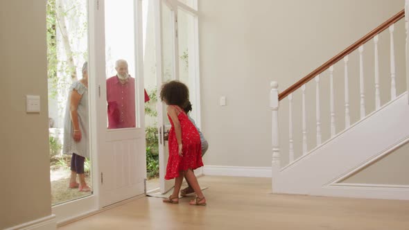 Grandparents embracing their grandchildren at home alt