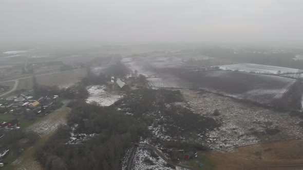Melting Snow on Field and Forest Misty Day Pull Back Drone View