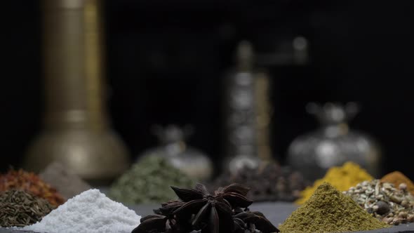 Oriental Spices on a Dark Background Move on a Steep Surface