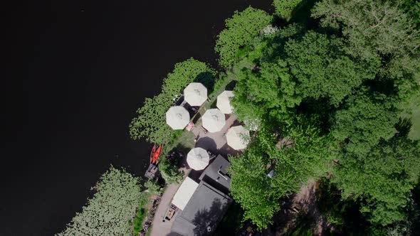 Drone Aerial Footage of the Umbrellas of a Small Cafe on the Lake Shore