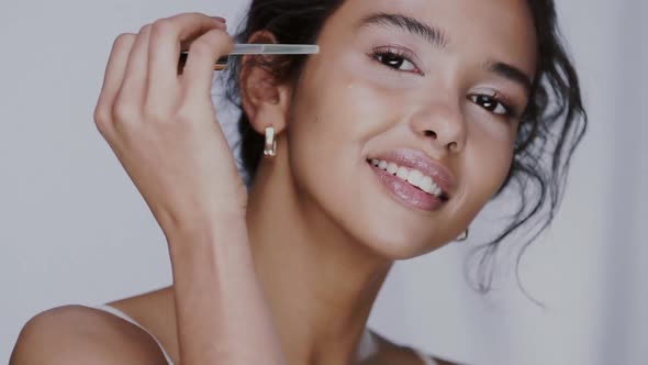 Pretty Woman with Healthy Skin Applying Serum on Her Face with Pipette and Smiling alt